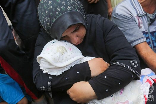 A woman in Gaza cradles her child after they passed away from malnutrition suffered amid Israeli occupation. (Credit: Wikimedia Commons)