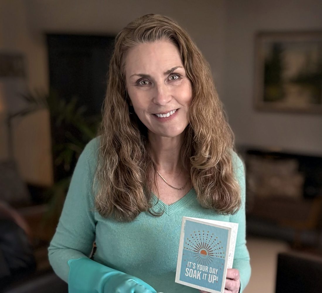 Carla Scholz, founder of Soak iT Up, created “Clards,” a patented greeting card made from Swedish dishcloth material that transforms into a reusable cleaning cloth when wet, offering a zero-waste alternative to traditional paper cards and towels.